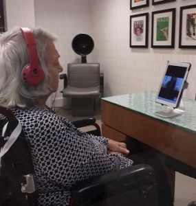 Old woman with headphones watching movie