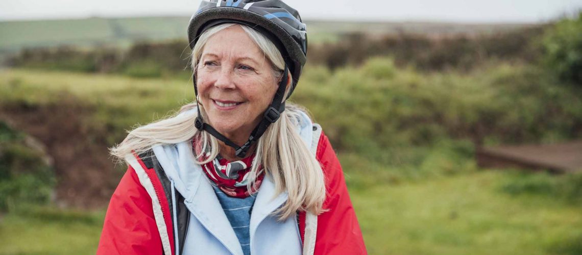 Old woman outside cycling